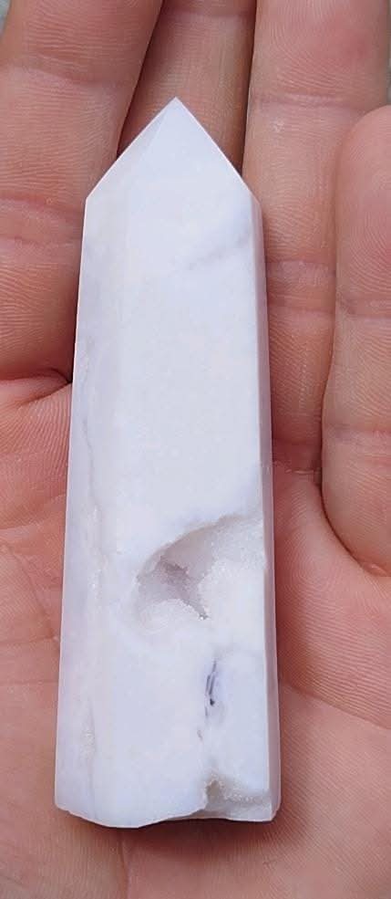 Pointe taillée et polie d'agate blanche avec druzy.